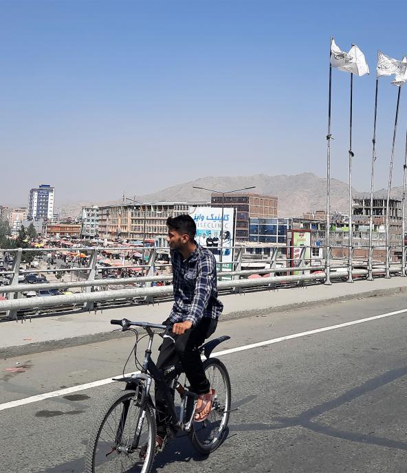 A biker on the bridge in the city center of Kabul