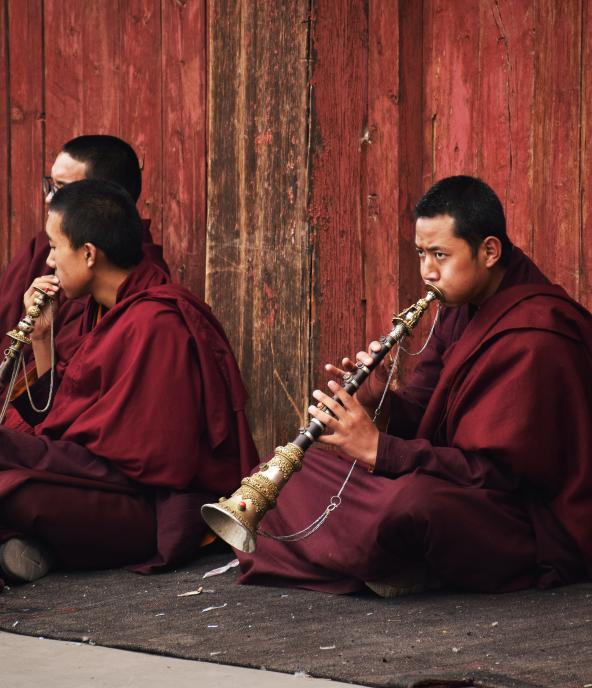 Buddhist monks playing a tibetan flute inside Sakya monastery, Tibet